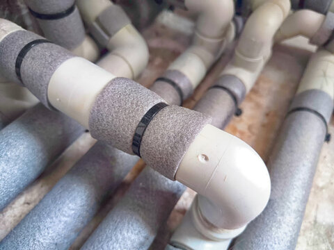 Complex Network of Insulated Pipes in an Industrial Setting. maze of thermally insulated pipes arranged in a complex network, part of industrial heating or cooling system