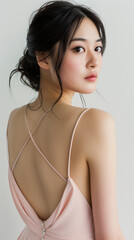 Portrait of beautiful Japanese women with slicked back hair, wearing backless halter gown in blush 
