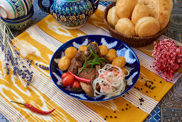 meat with potatoes, onions and tomatoes Oriental background