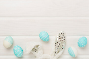 Blue easter eggs with bunny on wooden background, top view