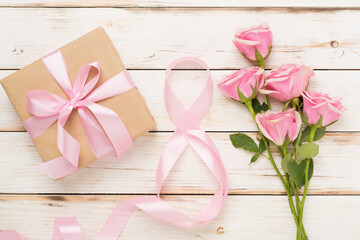 Composition with pink roses, gift box and eight made of ribbon on wooden background, top view. Women's day concept