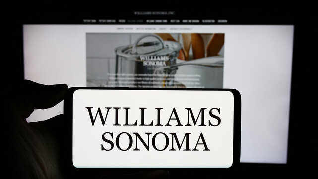 Stuttgart, Germany - 02-08-2024: Person holding cellphone with logo of US consumer retail company Williams-Sonoma Inc. in front of business webpage. Focus on phone display.