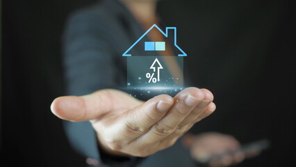 Businessman holding house and up arrow icon for home analysis,real estate interest rate investment...
