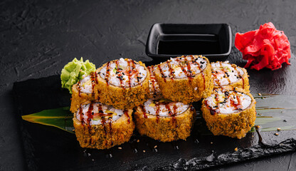 Warm sushi rolls with avocado on black