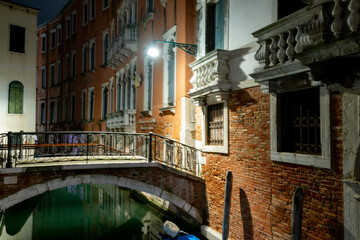 Fototapeta na wymiar Enge Gassen und Kanäle in Venedig bei Nacht, ohne Personen.