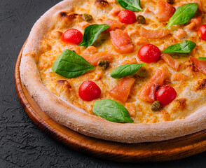 Tasty seafood pizza with tomatoes, cheese, salmon and basil