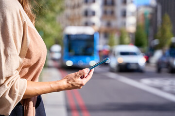 close-up detail of a woman's hand with a mobile phone calling for a cab