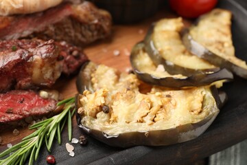 Delicious grilled eggplant and beef with spices on table, closeup