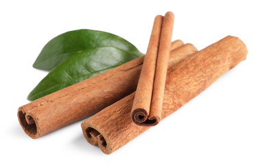 Cinnamon sticks and green leaves isolated on white