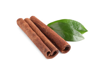 Cinnamon sticks and green leaves isolated on white