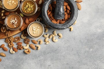 Making nut butters from different nuts. Flat lay composition with space for text on light grey table