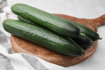 Fresh cucumbers on white tiled table, closeup