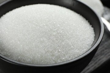 Granulated sugar in bowl on table, closeup