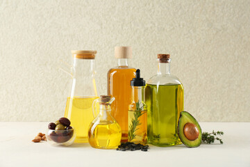 Vegetable fats. Different cooking oils in glass bottles and ingredients on white table