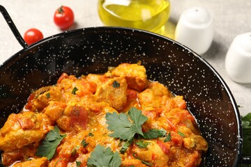 Delicious chicken curry in frying pan on table, closeup