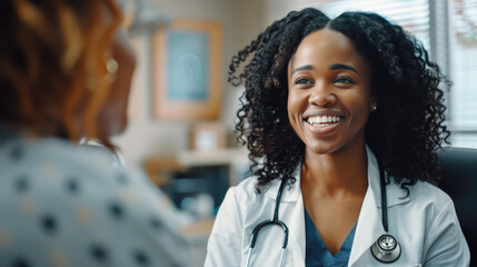 Smiling African american female doctor discussing treatment with patient in medical office. Therapist, general practitioner with stethoscope consulting patient during medical checkup visit - obrazy, fototapety, plakaty