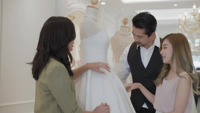 A female wedding planner and a wedding dress shop owner are giving advice on wedding arrangements and bridal gowns. Wedding planning business concept