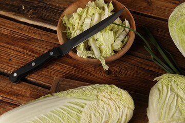 Whole and cut fresh Chinese cabbages on wooden table