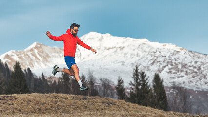 Naklejka na ściany i meble Man jumps running in the mountains
