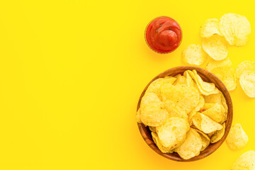 Crisps or potato chips with salt in wooden bowl, top view