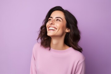Fototapeta premium Portrait of a happy young woman on a purple background smiling.