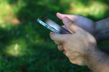 A male hand dealing with a smartphone