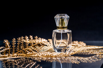 
A perfume bottle rests on a golden leaf.