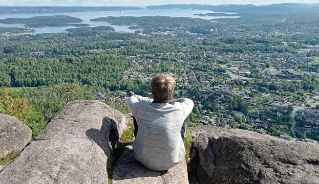 Man enjoy panoramic view to Oslo Fjord from Kolsstoppen mountain. Mt. Kolsastoppen, popular hiking area with spectacular panoramic views of Oslo, Berum, and the Oslo Fjord.