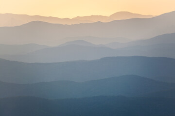Landscape. Mountain slopes in the mist at sunset