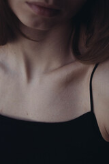 Bare neck, shoulders and collarbones of a beautiful woman.  Female body. The concept of loving yourself and your body. Beauty and details of the female body. Youth concept.