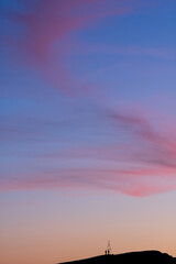Beautiful sky with clouds at sunset and silhouettes of people in the distance