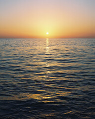Obraz premium Sunrise over calm ocean horizon (film photography)