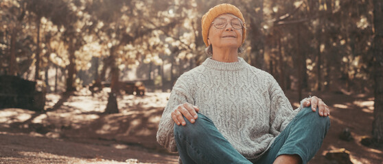 Head shot portrait close up of one middle age old woman resting and relaxing doing yoga in the...