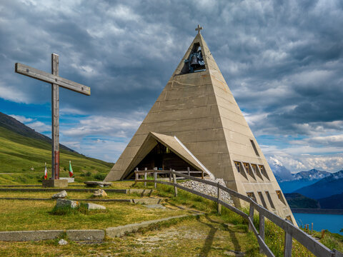 Modern pyramid shaped church and alpine lake in France.