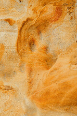 Natural texture background of sandstone rocks with lines, curves, prints in the As Amoeiras and Formosa beach cliffs in Santa Cruz, Portugal.