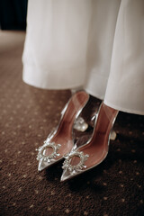 Bride's white trendy brand wedding shoes decorated with sequins close-up