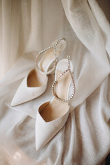 Bride's white trendy brand wedding shoes decorated with sequins close-up