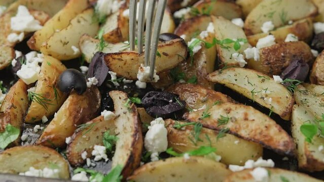 Eating Greek fried potatoes with feta cheese, kalamata olives and parsley and dill