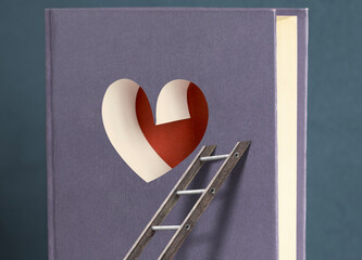 A book with a heart in the middle with a ladder attached to it. The concept of finding the path to love. Overcoming difficulties in love. 