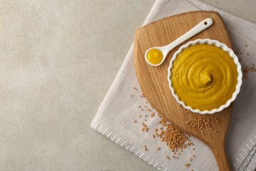 Tasty mustard sauce and dry seeds on light textured table, flat lay. Space for text