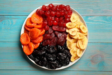 Delicious dried fruits on light blue wooden table, top view