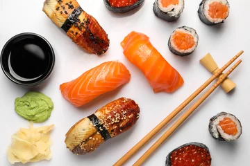 Selbstklebende Fototapeten Set of delicious sushi rolls on white background, flat lay © New Africa