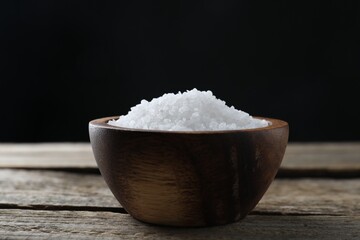 Organic salt in bowl on wooden table, closeup