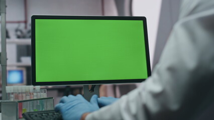 Doctor typing green screen computer in modern advanced laboratory close up.