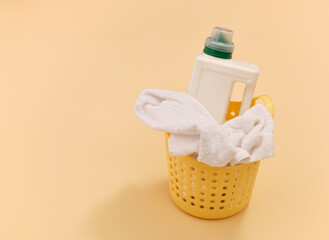Yellow laundry basket and detergent, towel. Copy space for text.
