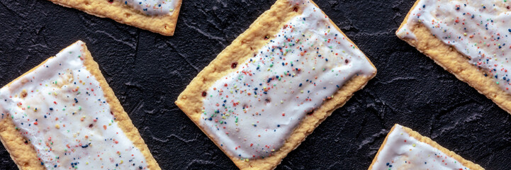 Pop tarts panorama. Poptart toaster pastry on a black background, overhead