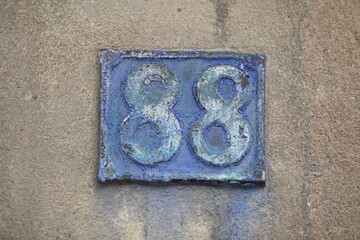 Vintage square ceramic street number plate with number. Close up, brand.