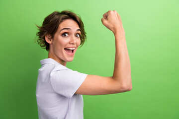 Closeup side photo of young lady show her perfect figure biceps fist up muscles hardworking sportswoman isolated on green color background