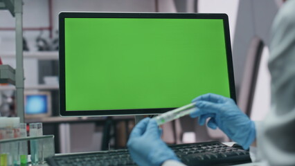 Chemist working chroma key monitor in laboratory close up. Scientist in gloves 