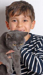 Happy kid holding a grey kitten cat. - 740125177